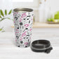 Pink Music Notes Pattern Travel Mug (15oz) at Amy's Coffee Mugs. A stainless steel travel mug designed with music notes and symbols in pink, black, and gray in a pattern that wraps around the travel mug. Photo shows the travel mug open on a table with the lid laying beside it. 