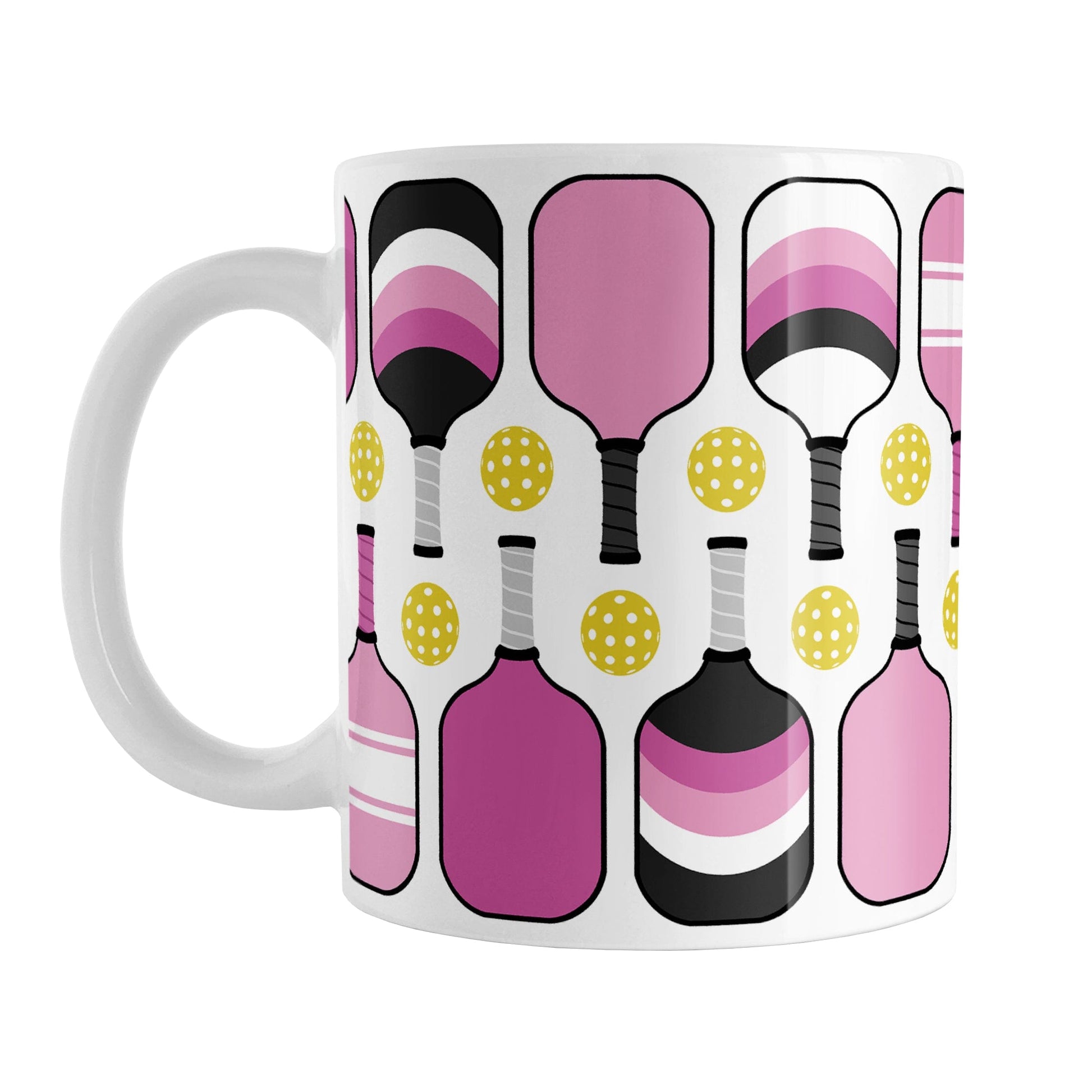 Pink Pickleball Mug (11oz) at Amy's Coffee Mugs. A ceramic coffee mug designed with modern pink pickleball paddles and yellow balls in a pattern that wraps around the mug up to the handle.