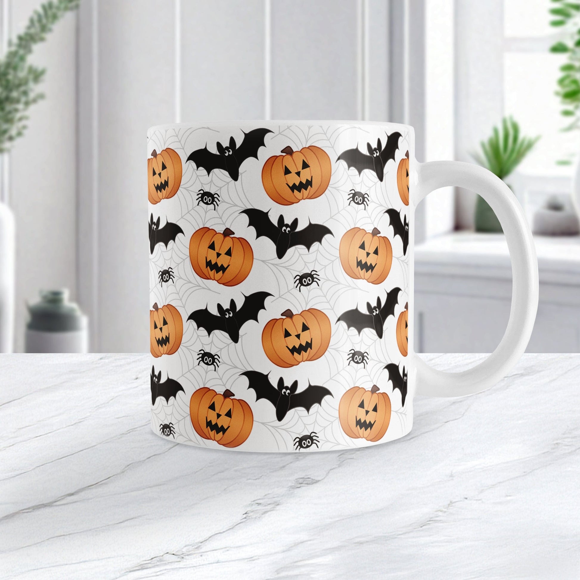 11oz mug with Halloween-themed design featuring pumpkins, bats, and spiders on a white marble surface.