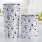 Purple Music Notes Pattern Tumbler Cups (20oz or 10oz) at Amy's Coffee Mugs. Stainless steel tumbler cups designed with music notes and symbols in purple, black, and gray in a pattern that wraps around the cups. Photo shows both sized cups on a table next to each other. 