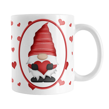 Red Gnome Dainty Hearts Mug (11oz) at Amy's Coffee Mugs. A ceramic coffee mug designed with an adorable red gnome in a white oval on both sides of the mug over a pattern of cute dainty hearts in different shades of red that wrap around the mug to the handle.