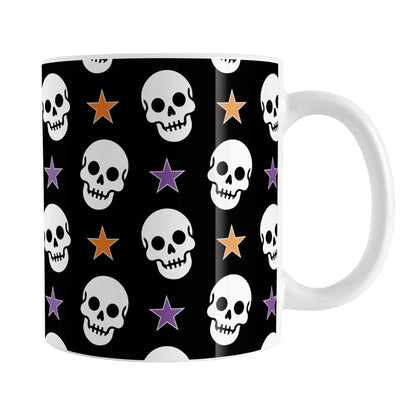 Skulls and Stars Halloween Mug (11oz) at Amy's Coffee Mugs. A ceramic coffee mug designed with white skulls and stars in orange and purple over a black background color in a pattern that wraps around the mug to the handle.