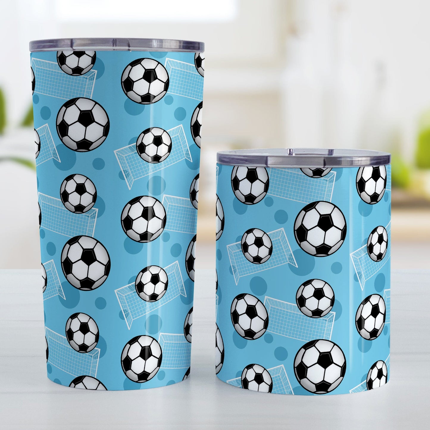 Soccer Ball and Goal Pattern Blue Tumbler Cup (20oz and 10oz) at Amy's Coffee Mugs. Stainless steel insulated tumbler cups designed with a pattern of soccer balls and goals over a blue background that wraps around the cups. These blue soccer tumbler cups are perfect for people who love or play soccer. Photo shows both sized cups next to each other.