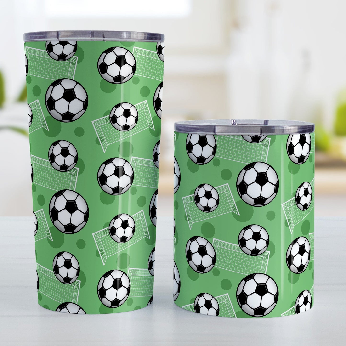 Soccer Ball and Goal Pattern Green Tumbler Cup (20oz and 10oz) at Amy's Coffee Mugs. Stainless steel insulated tumbler cups designed with a pattern of soccer balls and goals over a green background that wraps around the cups. These green soccer tumbler cups are perfect for people who love or play soccer. Photo shows both sized cups next to each other.