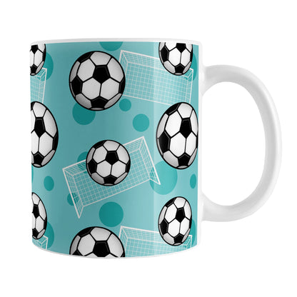 Soccer Ball and Goal Pattern Teal Mug (11oz) at Amy's Coffee Mugs. A ceramic coffee mug designed with a pattern of soccer balls and white soccer goals over a teal background with darker teal circles.