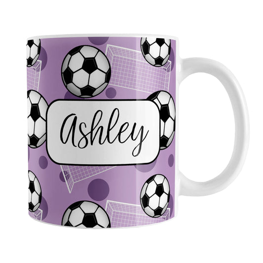 Soccer Ball and Goal Personalized Purple Soccer Mug (11oz) at Amy's Coffee Mugs. A ceramic coffee mug designed with a pattern of soccer balls and white soccer goals over a purple background with purple circles. Your personalized name is custom-printed in a fun black script font on both sides of the mug over the soccer pattern. 
