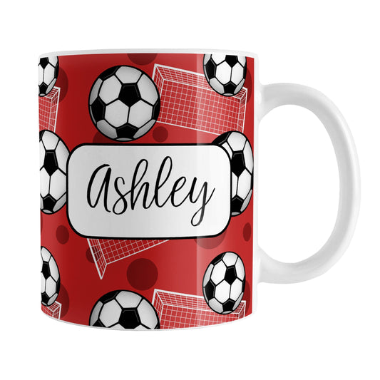 Soccer Ball and Goal Personalized Red Soccer Mug (11oz) at Amy's Coffee Mugs. A ceramic coffee mug designed with a pattern of soccer balls and white soccer goals over a red background with red circles. Your personalized name is custom-printed in a fun black script font on both sides of the mug over the soccer pattern. 