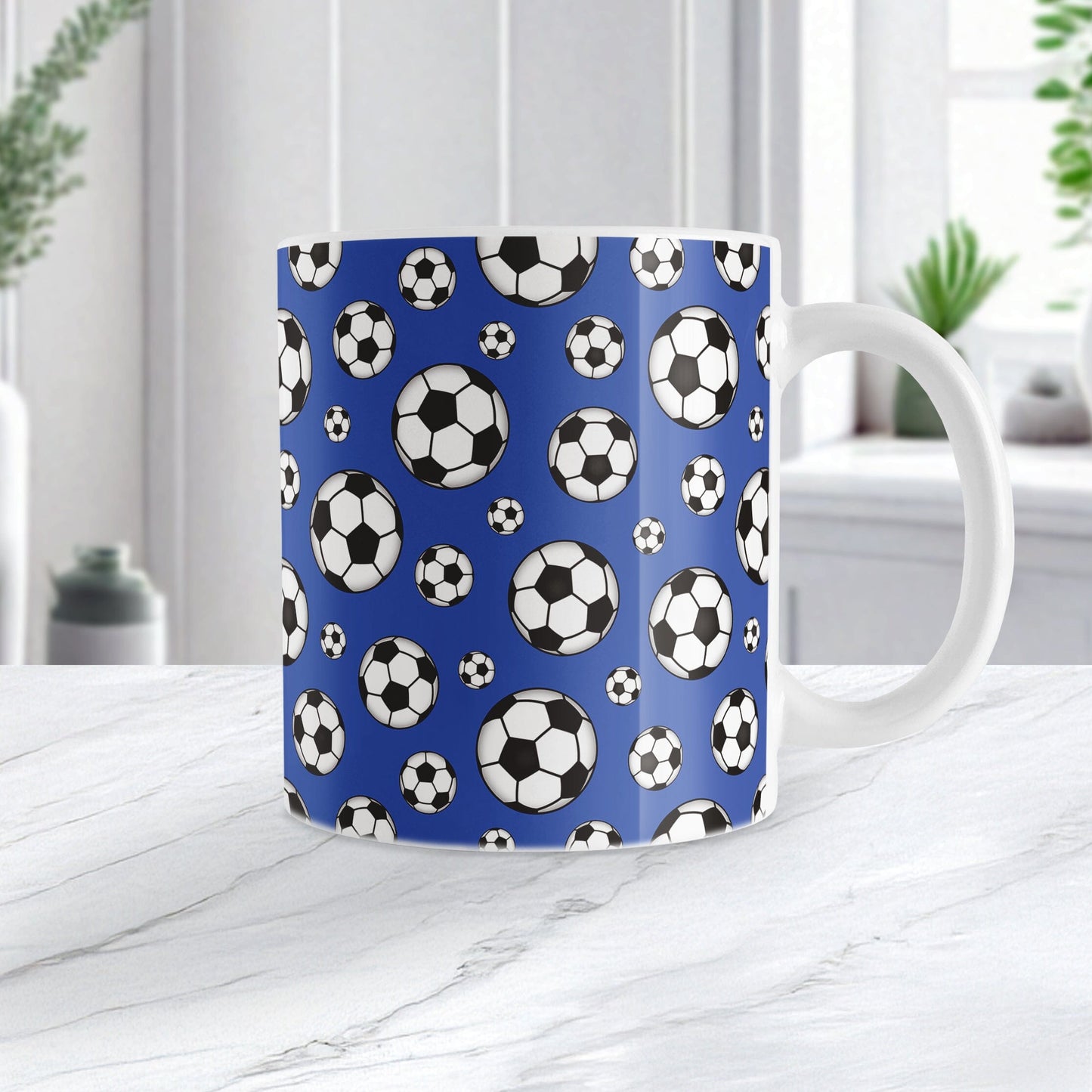 11oz white ceramic mug with a design of soccer balls over dark blue, on a marble countertop