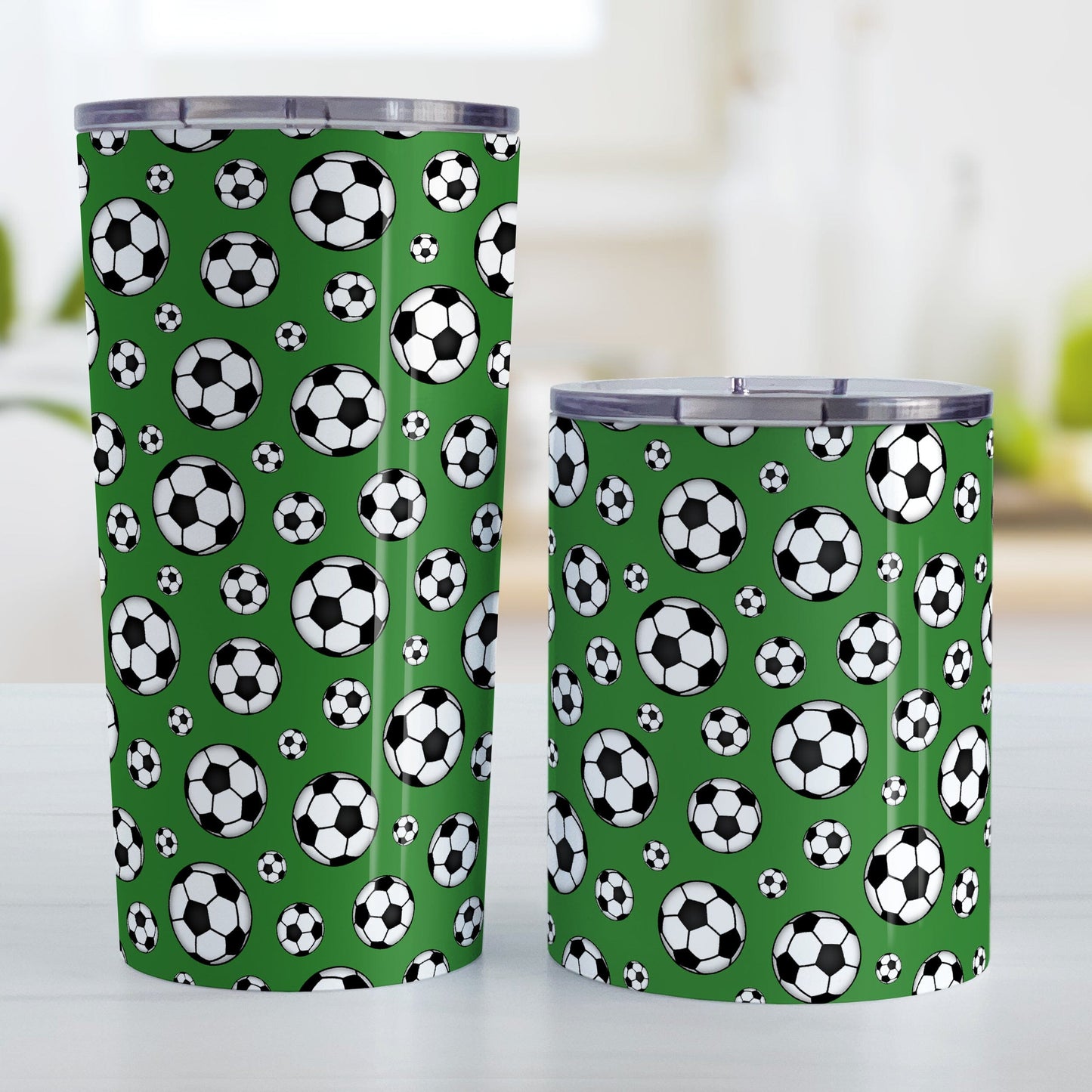 Soccer Balls on Dark Green Tumbler Cup at Amy's Coffee Mugs. Photo shows the 20oz cup and the 10oz cup on a table next to each other.