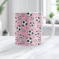 11oz white ceramic mug with a design of soccer balls over pink, on a marble countertop