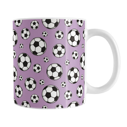11oz white ceramic mug with a design of soccer balls over purple