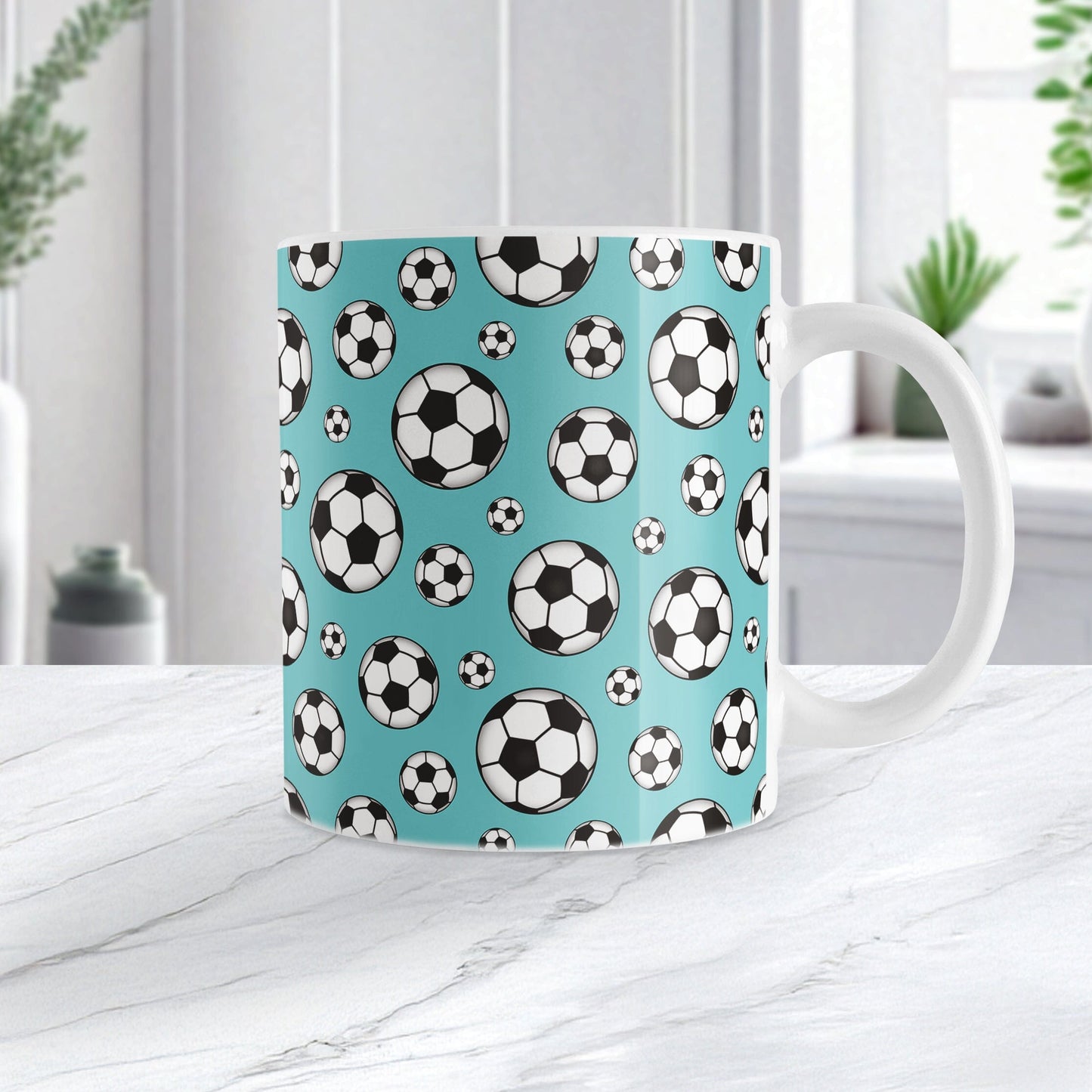 11oz white ceramic mug with a design of soccer balls over teal, on a marble countertop