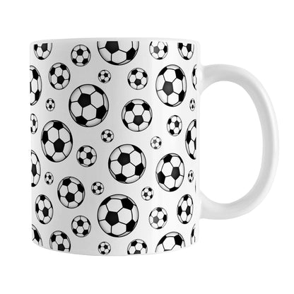 Soccer Balls Pattern Mug (11oz) at Amy's Coffee Mugs. A ceramic coffee mug designed with black and white soccer balls in varying sizes in a pattern that wraps around the mug to the handle. It's perfect for anyone who loves the game of soccer.