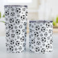 Soccer Balls Pattern Tumbler Cup (20oz and 10oz) at Amy's Coffee Mugs. A stainless steel tumbler cup designed with black and white soccer balls in varying sizes in a pattern that wraps around the cup. Photo shows both sized mugs on a table next to each other.