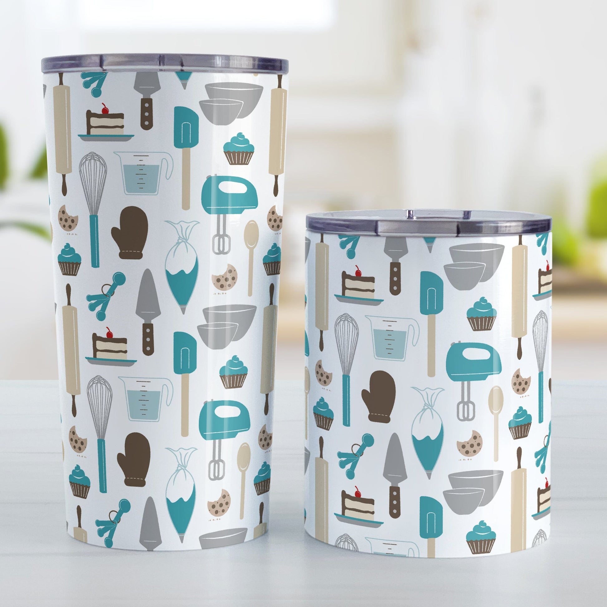 Turquoise Baking Pattern Tumbler Cups (20oz or 10oz) at Amy's Coffee Mugs. Stainless steel tumbler cups designed with a pattern of baking tools like spatulas, whisks, mixers, bowls, and spoons, with cookies, cupcakes, and cake all in a turquoise, gray, brown, and beige color scheme that wraps around the cups. Photo shows both sized cups on a table next to each other.