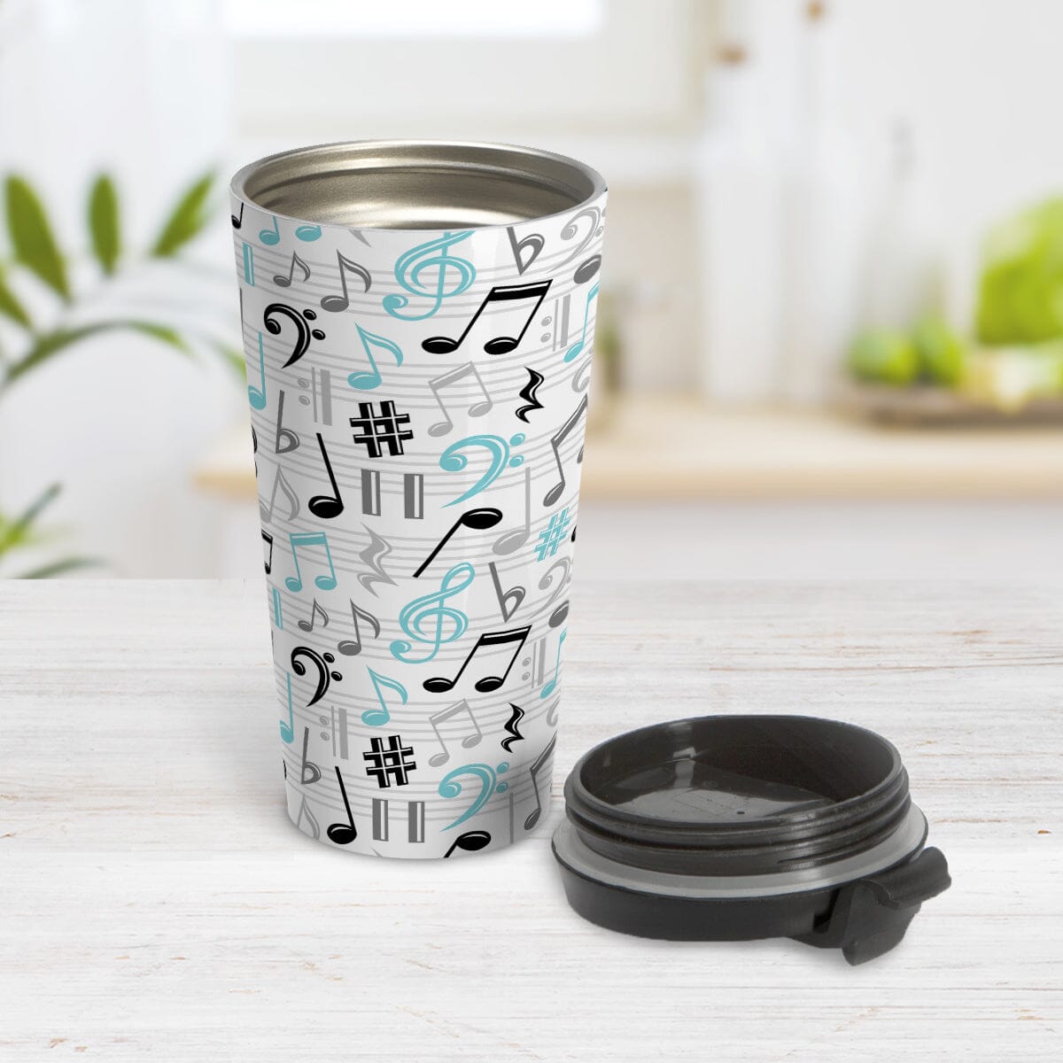 Turquoise Music Notes Pattern Travel Mug (15oz) at Amy's Coffee Mugs. Shown on tabletop with lid laying next to the travel mug. 