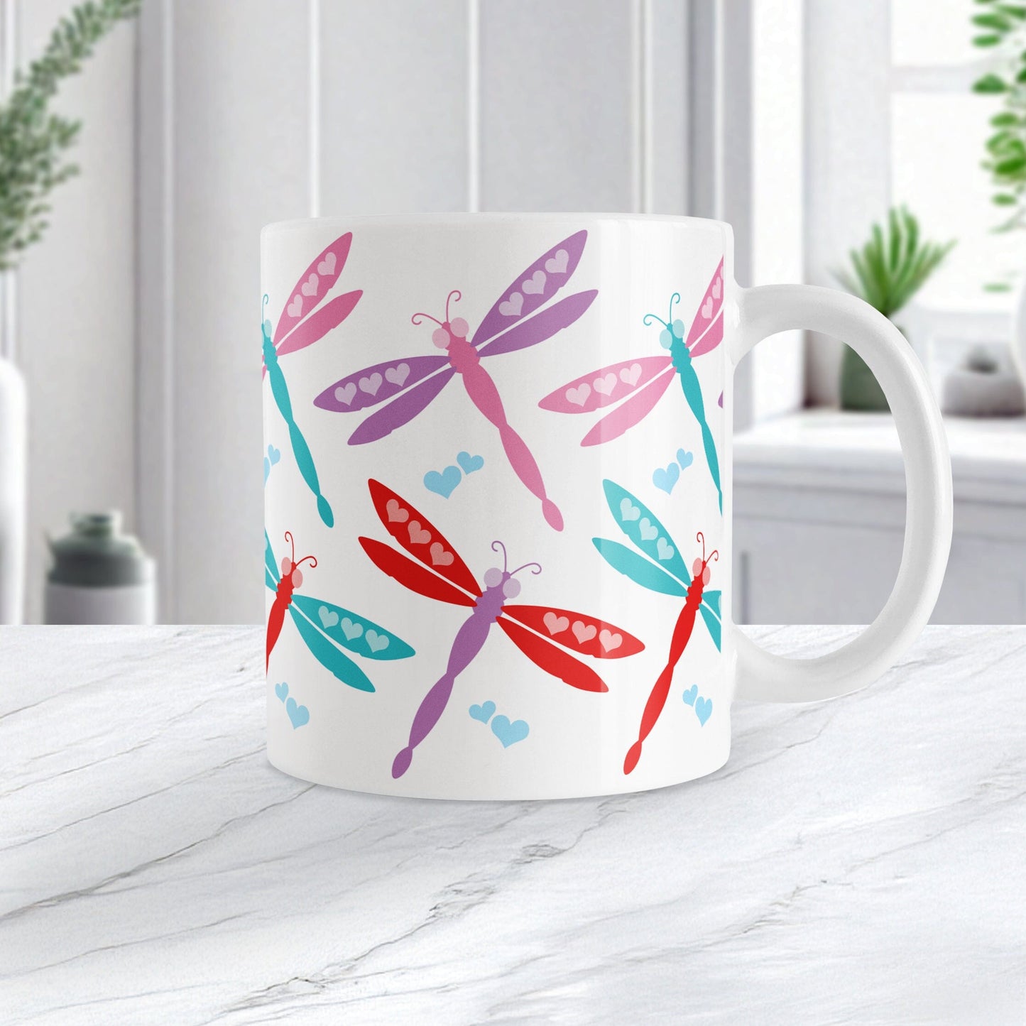 11oz white ceramic coffee mug with a colorful dragonfly design, perfect for Valentine's Day. Photo shows the mug on a marble countertop.