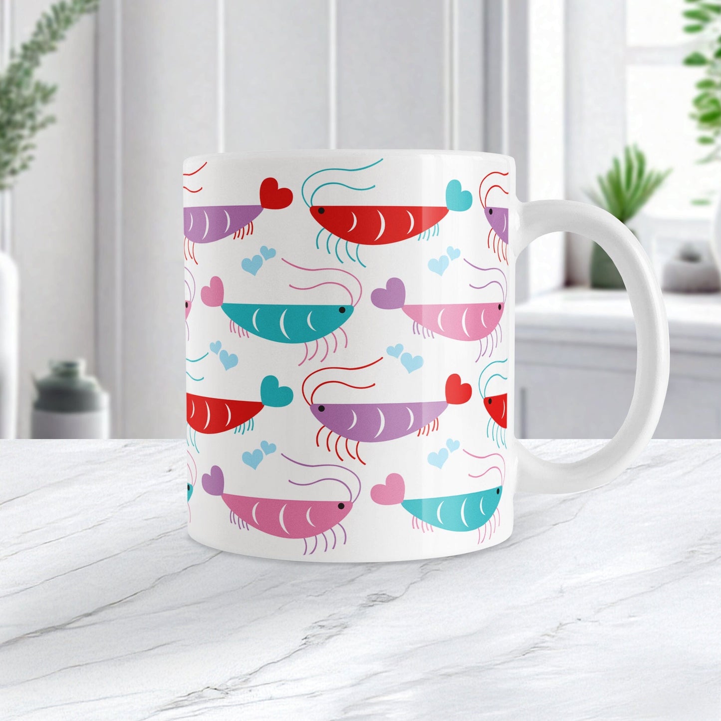 An 11oz white mug with a cute pattern of pink, purple, red, and teal shrimp, perfect for Valentine's Day. The photo shows the mug sitting on a marble countertop.