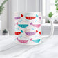 An 11oz white mug with a cute pattern of pink, purple, red, and teal shrimp, perfect for Valentine's Day. The photo shows the mug sitting on a marble countertop.