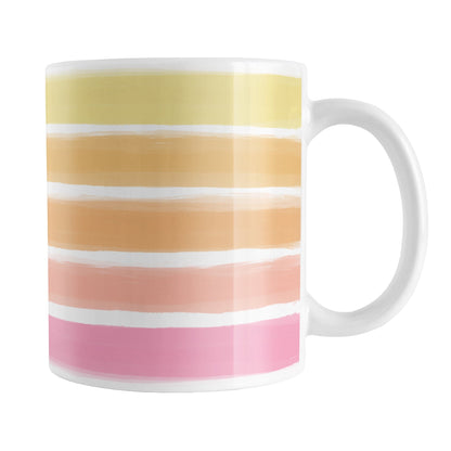 Warm Paint Strokes Mug (11oz) at Amy's Coffee Mugs. A ceramic coffee mug designed with a pattern of horizontal stripes done in a paint strokes illustration in warm colors that wraps around the mug to the handle. These warm colors include pink, peach, orange, and yellow tones.