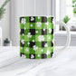 11oz mug with green and black checkered (buffalo plaid) pattern and white shamrocks and four-leaf clovers, on a marble countertop