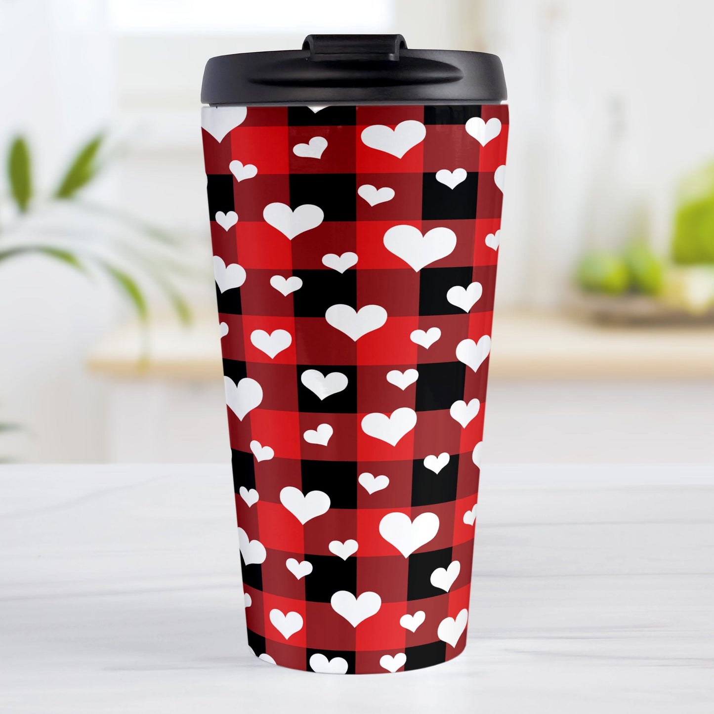 15oz travel mug with red and black buffalo plaid pattern with white hearts, on a tabletop