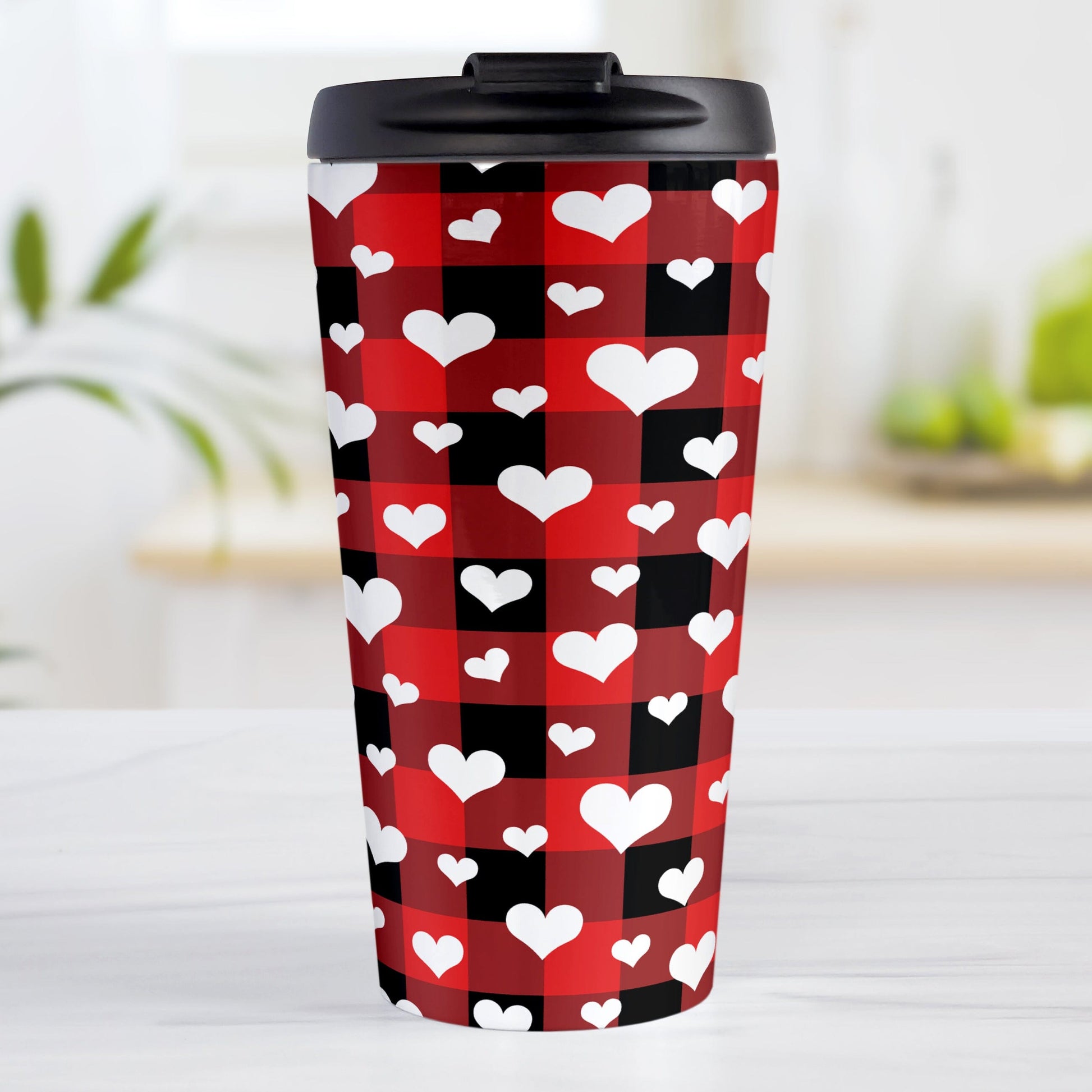 15oz travel mug with red and black buffalo plaid pattern with white hearts, on a tabletop