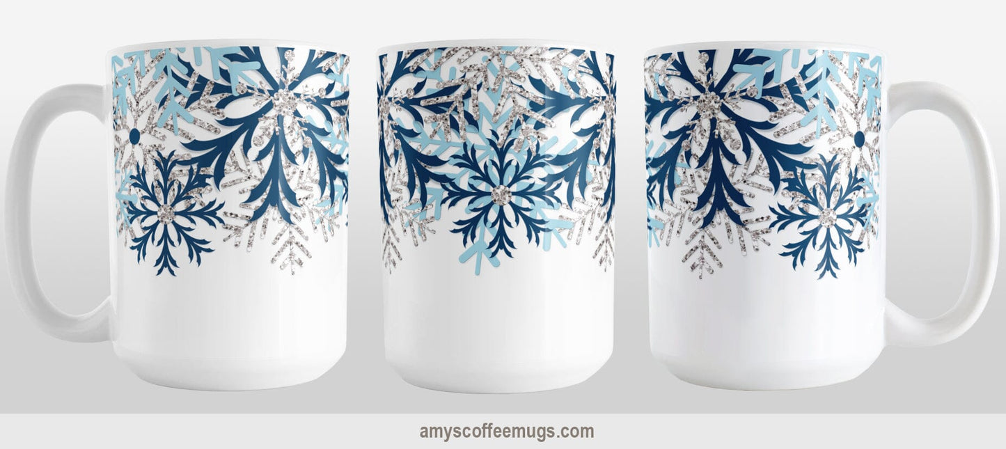 Winter Blue Silver Snowflake Mug (15oz) at Amy's Coffee Mugs. A ceramic coffee mug with navy blue, aqua blue, and silver-colored glitter-illustrated snowflakes along the top, cascading down most of the mug, over white. This wintry snowflake design wraps around the mug up to the handle. This image shows three sides of the mug to give a full view of the design.