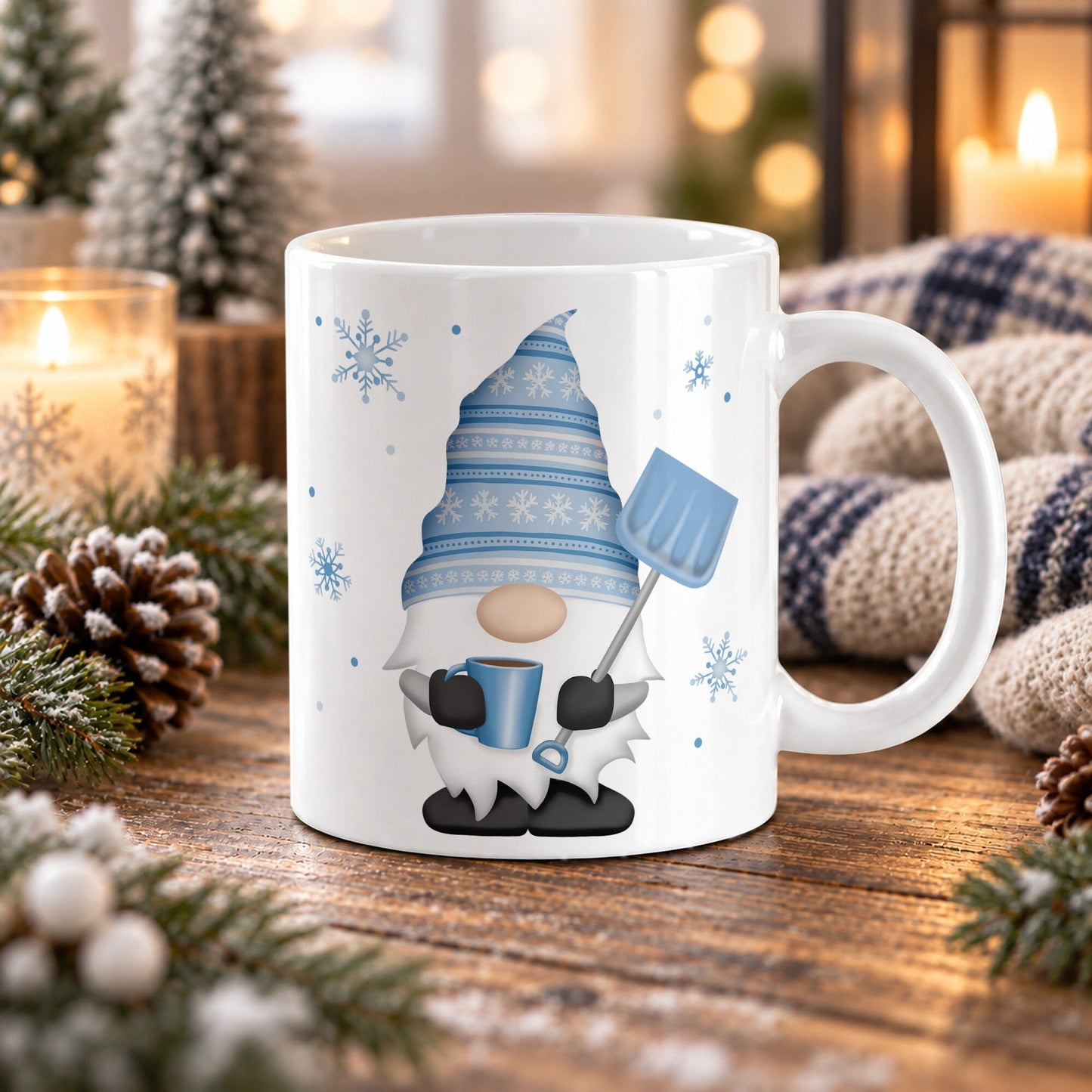11 oz winter gnome mug with blue snowflake hat, blue coffee mug, light blue snow shovel, and snowflakes on white ceramic, displayed on a wooden table with winter decor around it.