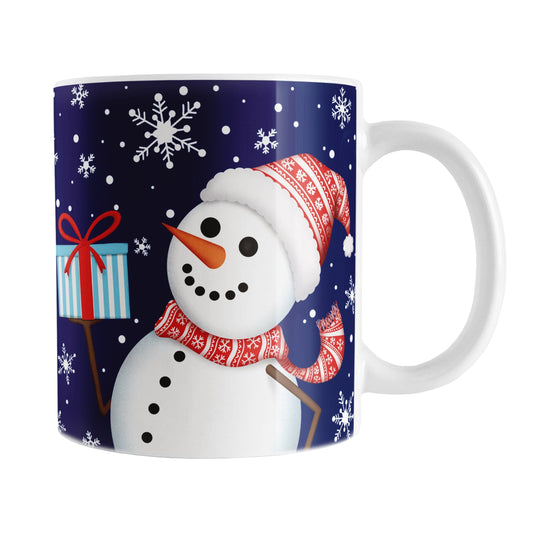 Winter Snowman Mug (11oz) at Amy's Coffee Mugs. A ceramic coffee mug designed with an illustration of a happy snowman wearing a red scarf and hat, while holding a blue gift box, over a winter night sky background with snowflakes around him.