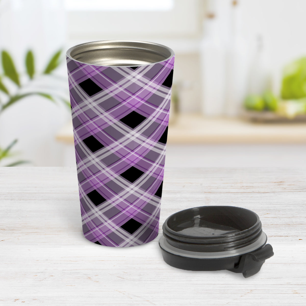 Alternative Purple Plaid Travel Mug (15oz) at Amy's Coffee Mugs. A stainless steel travel mug designed with a diagonal purple, black, and white plaid pattern that wraps around the mug. Designed for someone who likes plaid patterns and loves the color purple. Photo shows the mug open with the lid on the table beside it.