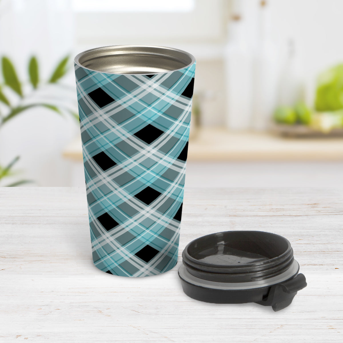 Alternative Turquoise Plaid Travel Mug (15oz) at Amy's Coffee Mugs. A stainless steel travel mug designed with a diagonal turquoise, black, and white plaid pattern that wraps around the mug. Designed for someone who likes plaid patterns and loves the color turquoise. Photo shows the mug open with the lid on the table beside it.