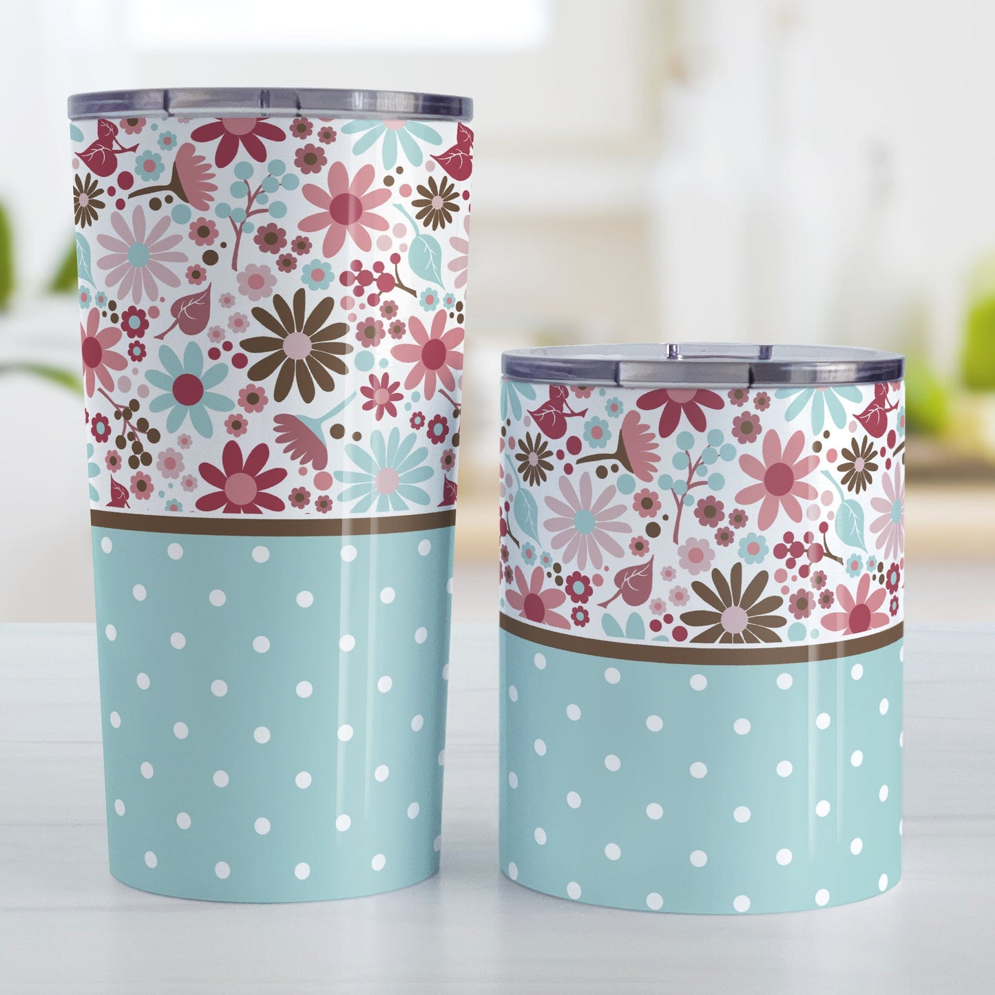 Berry Blue Summer Flowers Polka Dot Tumbler Cups (20oz or 10oz) at Amy's Coffee Mugs. Stainless steel tumbler cups designed with a pretty floral pattern in a gorgeous berry pink color palette with light blue and brown along the top, and a light blue polka dot pattern along the bottom. These patterns wrap around the cups. Photo shows both sized cups on a table next to each other. 