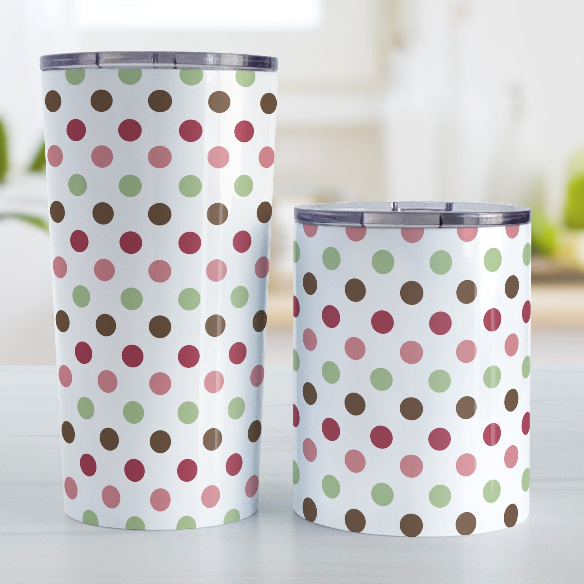Berry Green Polka Dots Tumbler Cup (20oz or 10oz) at Amy's Coffee Mugs. Stainless steel tumbler cups designed with a pattern of polka dots a color palette of berry pink hues, sage green, and brown that wraps around the cups. Photo shows both sized cups next to each other on a table.