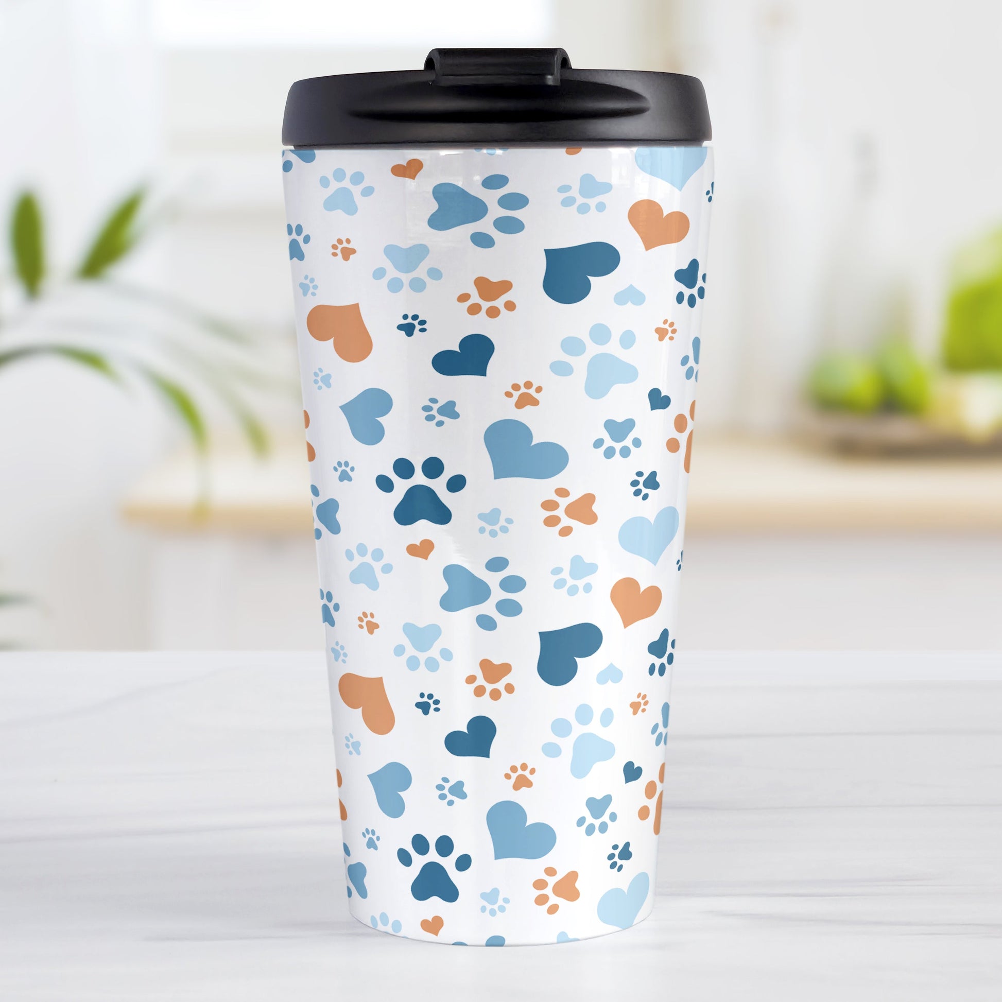Blue Hearts and Paw Prints Travel Mug (15oz) at Amy's Coffee Mugs. A stainless steel travel mug designed with a pattern of hearts and paw prints in orange and different shades of blue that wraps around the mug. This travel mug is perfect for people love dogs and cute paw print designs.