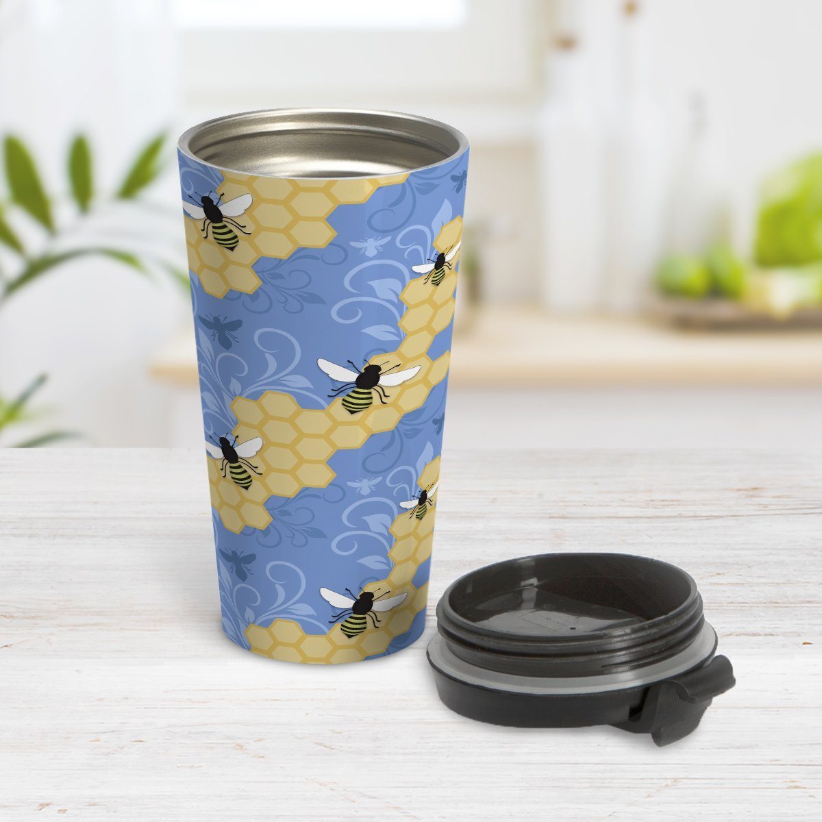 Blue Honeycomb Bee Travel Mug at Amy's Coffee Mugs. A travel mug designed with a pattern of black and yellow bees on honeycomb lines over a blue flourish background that wraps around the tapered shaped mug.