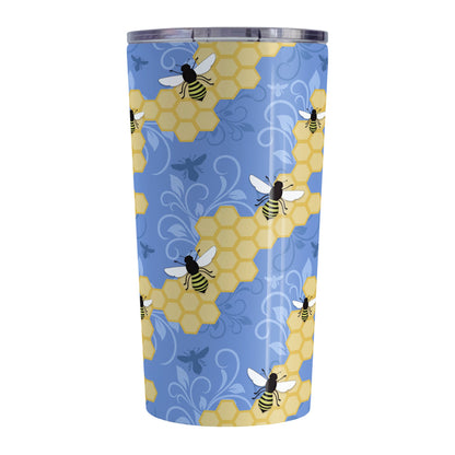 Blue Honeycomb Bee Tumbler Cup (20oz, stainless steel insulated) at Amy's Coffee Mugs. A tumbler cup designed with a pattern of black and yellow bees on honeycomb lines over a blue flourish background that wraps around the cup.