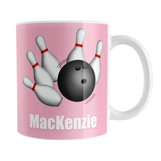 Bowling Ball and Pins Pink - Personalized Bowling Mug (11oz) at Amy's Coffee Mugs. A ceramic coffee mug designed with an illustration of a bowling ball striking bowling pins on both sides of the mug over pink background color that wraps around the mug up to the handle. Your personalized name is custom printed in white below the bowling ball and pins.