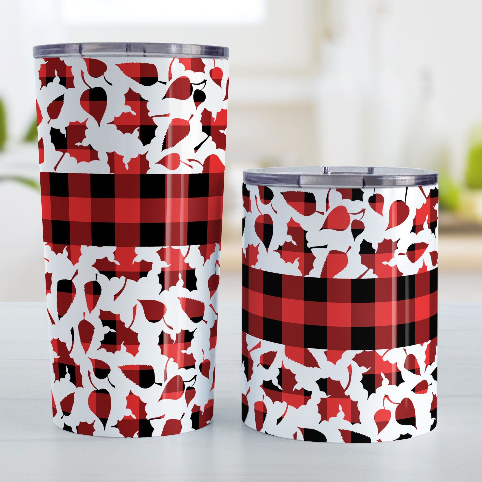 Buffalo Plaid Leaves Fall Tumbler Cup (20oz or 10oz) at Amy's Coffee Mugs. Stainless steel insulated tumbler cups designed with a pattern of leaves with a red and black buffalo plaid pattern that wraps around the cups. There is a buffalo plaid stripe over the middle area of the leaves. Photo shows both sized cups next to each other.