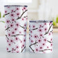 Cherry Blossom Tumbler Cup (20oz and 10oz) at Amy's Coffee Mugs. Stainless steel insulated tumbler cups designed with a pattern of pink cherry blossom flowers on branches that wraps around the cups. Photo shows both sized cups next to each other.