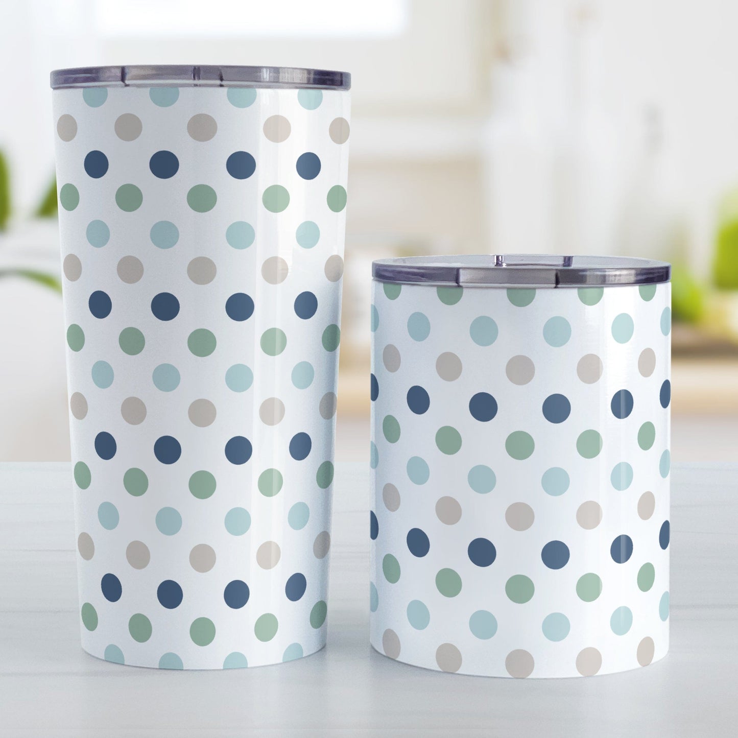 Coastal Polka Dots Tumbler Cups (20oz of 10oz) at Amy's Coffee Mugs. Stainless steel tumbler cups designed with a pattern of polka dots in a coastal color scheme that wraps around the cups. Photo shows both sized cups on a table next to each other.