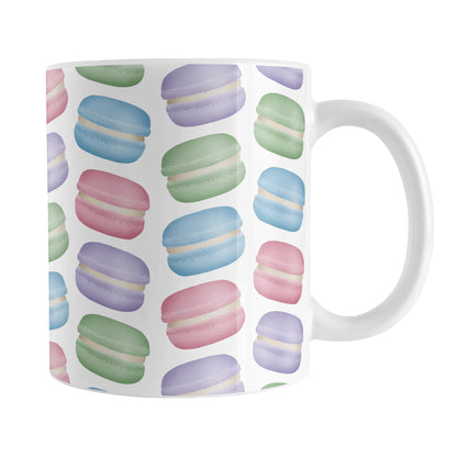Colorful Pastel Macarons Mug (11oz) at Amy's Coffee Mugs. A ceramic coffee mug designed with colorful pastel macarons colored in pink, purple, green, and blue in a pattern that wraps around the mug to the handle.