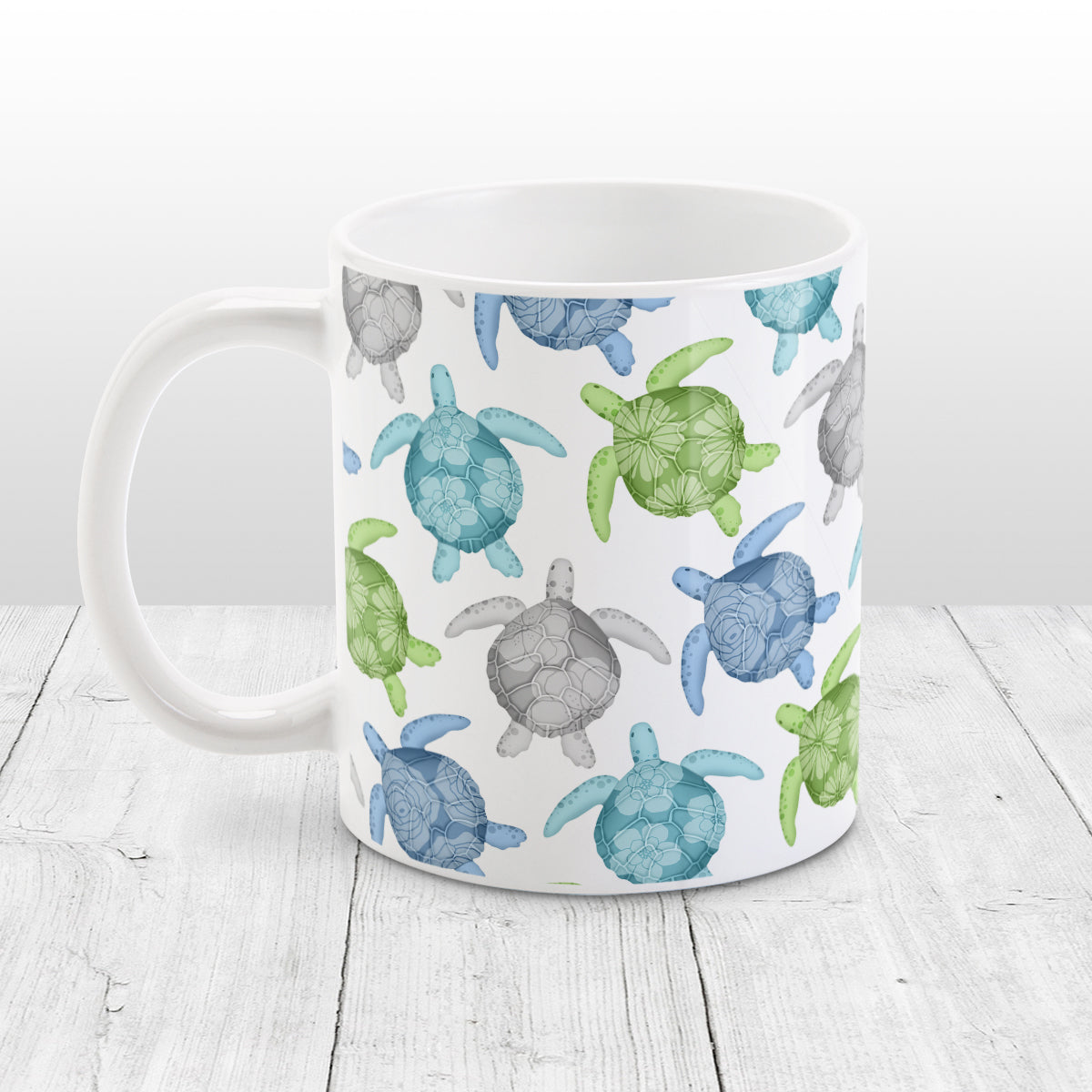 Cool Sea Turtles Pattern Mug (11oz) at Amy's Coffee Mugs. A ceramic mug with a pattern of sea turtles in a cool color palette of blue, green, turquoise and gray that wraps around the mug to the handle. Each cool colored sea turtle has a different floral watermark over its shell.