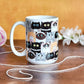 Cute Cat Stack Pattern Mug (15oz) at Amy's Coffee Mugs. Cute cats mug with an illustrated pattern of different breeds of cats with different fun expressions, with yarn, coffee, and donuts. This stacked pattern of cats wraps around the ceramic mug to the handle. The mug is shown sitting on a table with yarn and flowers.