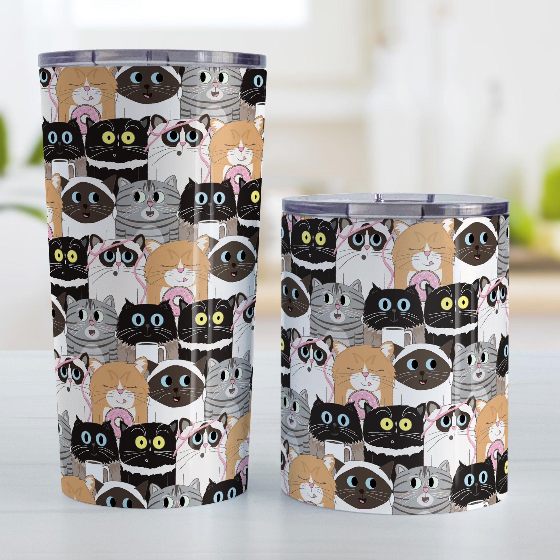 Cute Cat Stack Pattern Tumbler Cup (20oz and 10oz, stainless steel insulated) at Amy's Coffee Mugs. Cute cats tumbler cups with an illustrated pattern of different breeds of cats with different fun expressions, with yarn, coffee, and donuts. This stacked pattern of cats wraps around the cups. Picture shows both cup sizes on a counter next to each other.