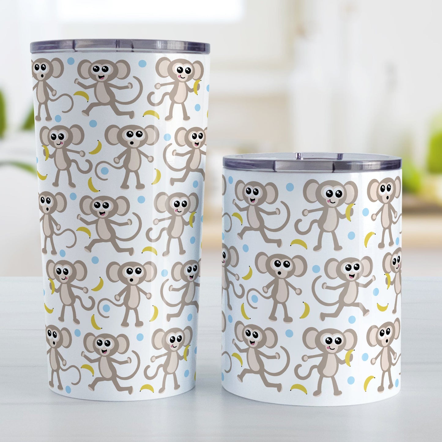 Cute Monkey Pattern with Blue Dots Tumbler Cup (20oz or 10oz) at Amy's Coffee Mugs. Stainless steel tumbler cups designed with an adorable pattern of monkeys having fun, complete with bananas and blue dots around them, that wraps around the cups. Photo shows both size cups on a table next to each other.