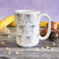 Cute Monkey Pattern with Pink Dots Mug (15oz) at Amy's Coffee Mugs. A ceramic coffee mug is designed with an adorable pattern of monkeys having fun, complete with bananas and pink dots, that wraps around the mug. Photo shows the mug in a purple and wood background with donuts and bananas on the table beside it.