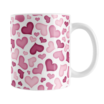 Cute Pink Hearts Pattern Mug (11oz) at Amy's Coffee Mugs. A ceramic coffee mug designed with a multi-directional pattern of cute hearts in different shades of pink that wrap around the mug to the handle.