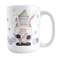 Easter Eggs Bunny Gnome Mug (15oz) at Amy's Coffee Mugs. A ceramic coffee mug designed with an adorable gnome with bunny ears and holding a large Easter egg. Colorful little Easter eggs lay on the ground beside him with little flowers floating around.