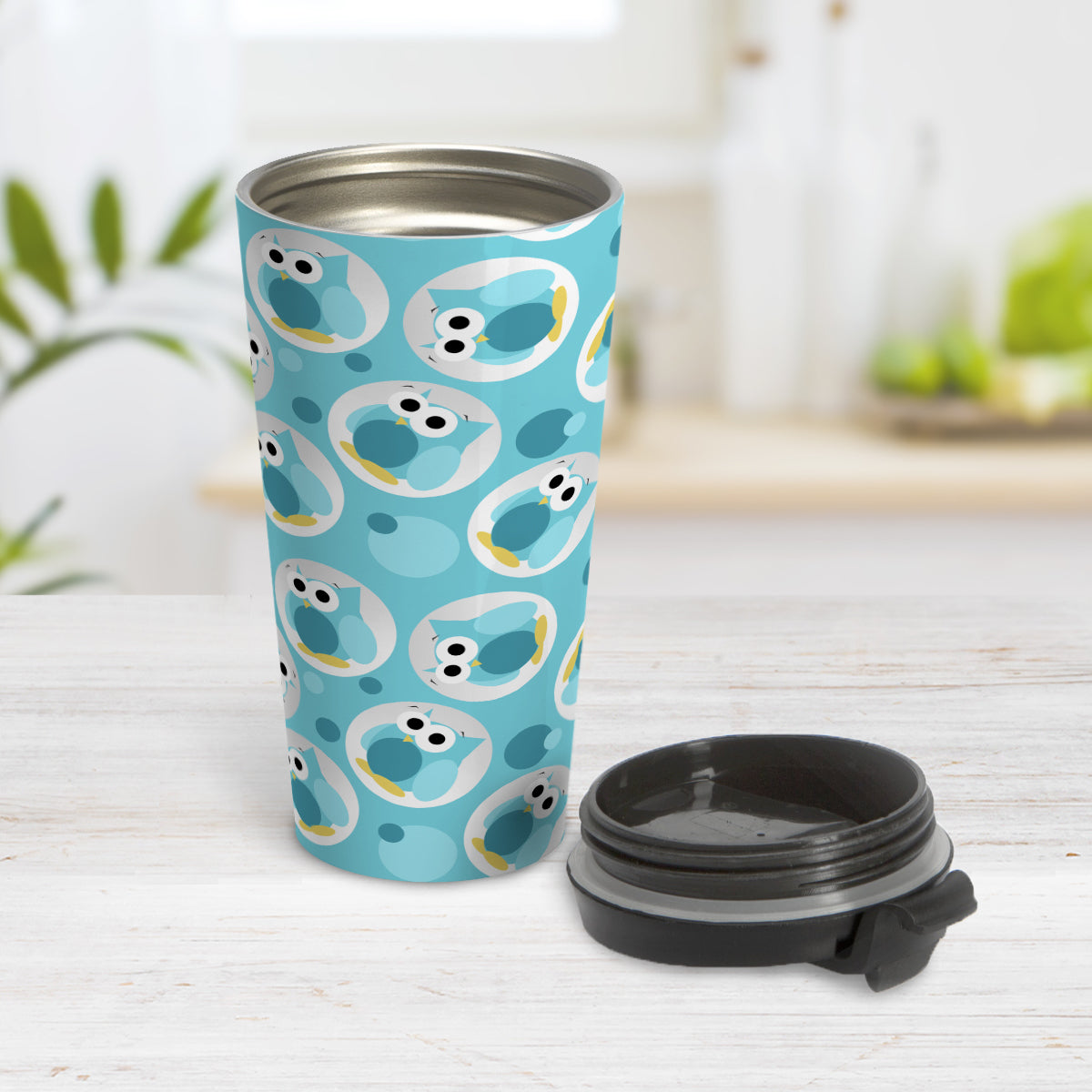 Funny Cute Turquoise Owl Pattern Travel Mug (15oz) at Amy's Coffee Mugs. A travel mug designed with a pattern of funny and cute turquoise owls in a light gray circles scattered over a turquoise background color that wraps around the travel mug. Photo shows mug open on a table with its lid next to it.